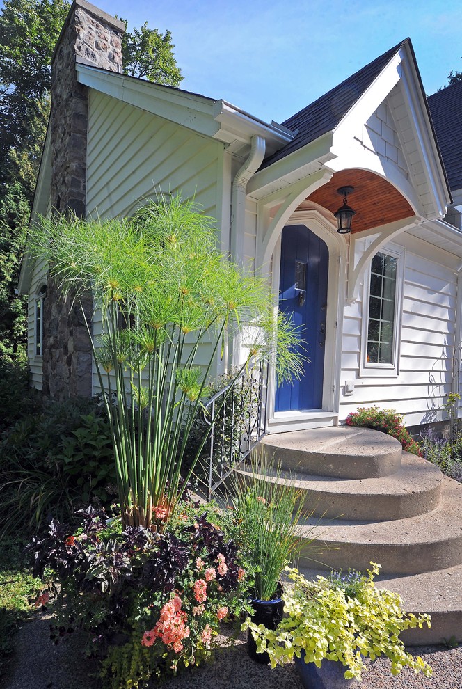 Inspiration for a small traditional bungalow house exterior in Milwaukee with wood cladding.