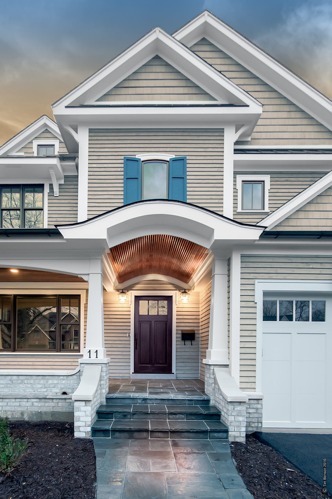 Foto de fachada de casa beige clásica renovada de tamaño medio de dos plantas con revestimientos combinados, tejado a dos aguas y tejado de teja de madera