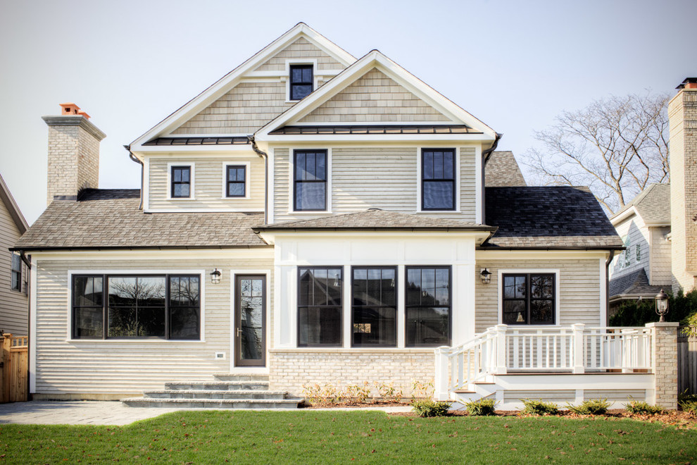 Diseño de fachada de casa beige de estilo americano de tamaño medio de dos plantas con revestimientos combinados, tejado a dos aguas y tejado de teja de madera