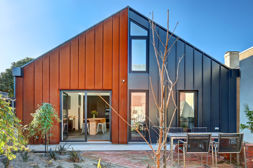 Diseño de fachada de casa multicolor actual pequeña de una planta con revestimiento de metal, tejado a dos aguas y tejado de metal