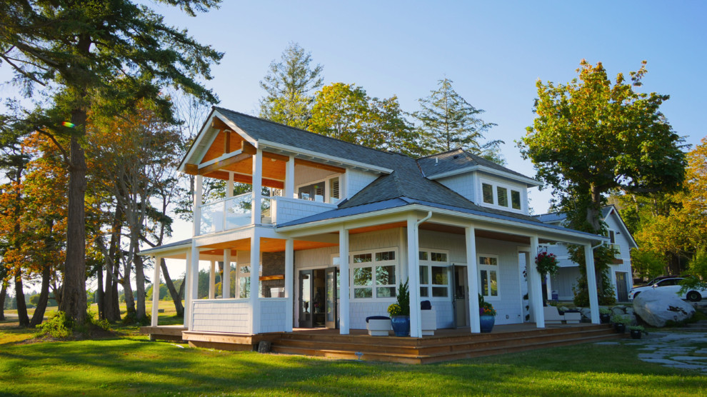 Foto de fachada de casa blanca costera grande de dos plantas con revestimiento de madera, tejado a dos aguas y tejado de teja de madera