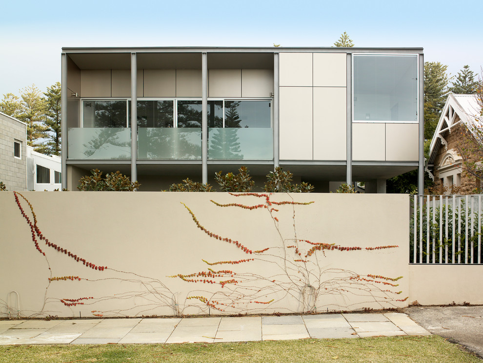 Imagen de fachada beige de dos plantas con tejado plano