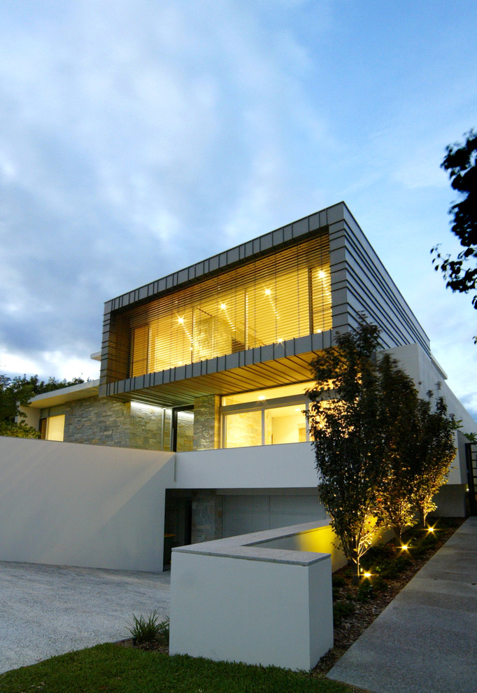На фото: трехэтажный, серый дом в современном стиле с облицовкой из металла и плоской крышей с