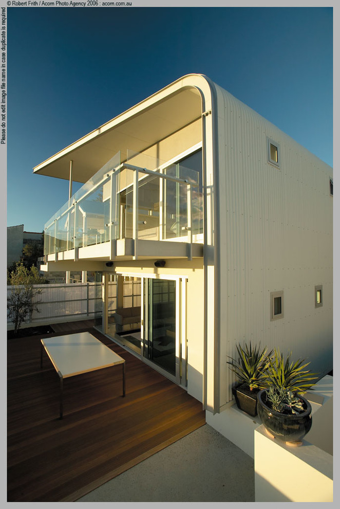 Modelo de fachada contemporánea de tamaño medio de dos plantas con revestimiento de metal y tejado plano