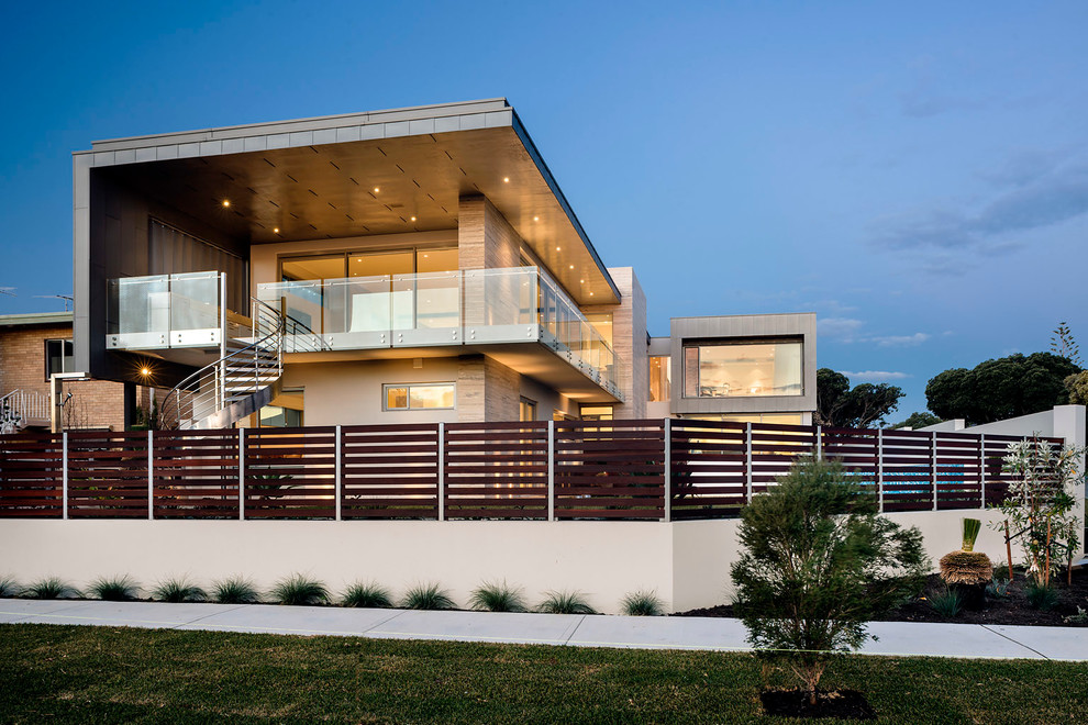 Idées déco pour une façade de maison beige moderne à un étage avec un toit plat.
