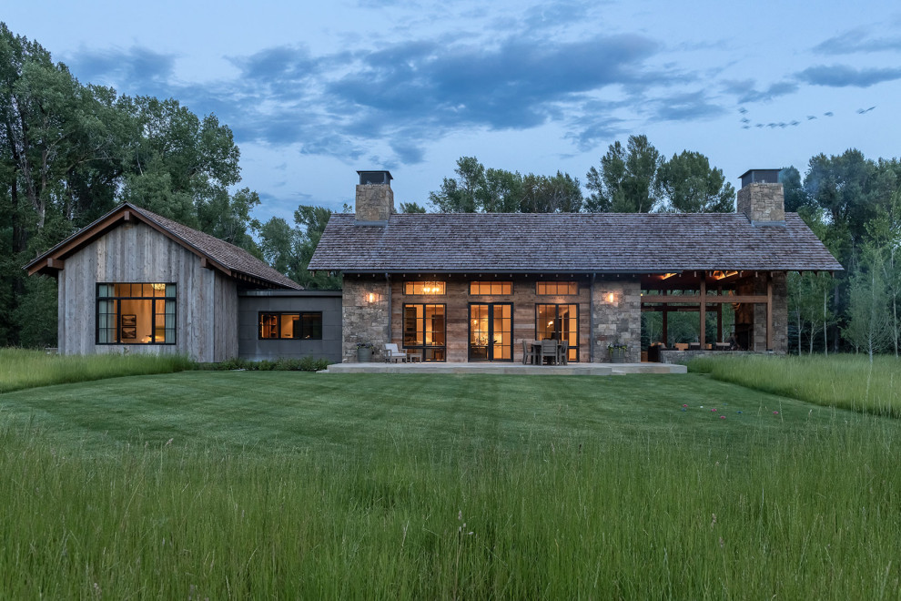 Einstöckiges Country Haus mit Mix-Fassade, grauer Fassadenfarbe, Satteldach und Schindeldach in Sonstige