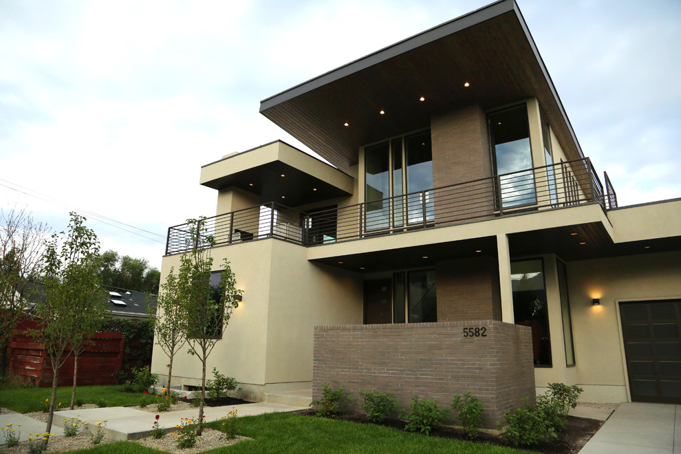 На фото: двухэтажный, бежевый дом среднего размера в современном стиле с комбинированной облицовкой и плоской крышей с