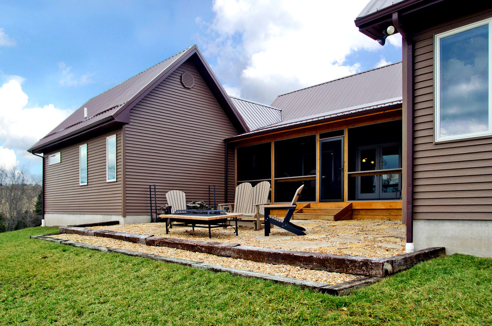 На фото: одноэтажный, деревянный, коричневый дом среднего размера в стиле рустика с двускатной крышей