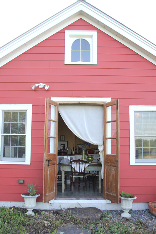 Esempio della facciata di una casa rossa eclettica a un piano di medie dimensioni