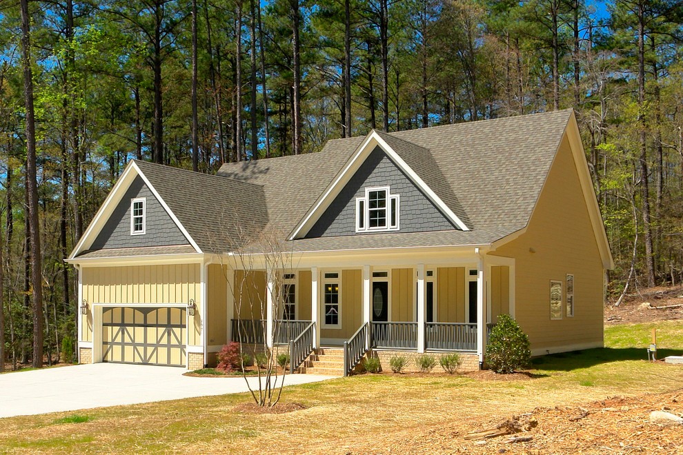 Example of a mid-sized classic yellow two-story mixed siding exterior home design in Raleigh