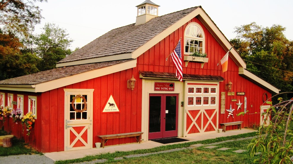 Immagine della facciata di una casa rossa country a un piano di medie dimensioni con rivestimento in legno e tetto a capanna