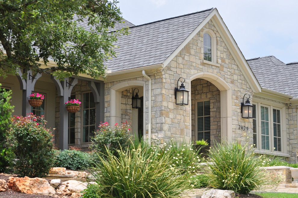 Inspiration for a large timeless beige one-story stone exterior home remodel in Austin with a hip roof