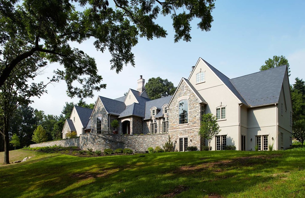 Photo of a large traditional two floor house exterior in Philadelphia with stone cladding and a pitched roof.