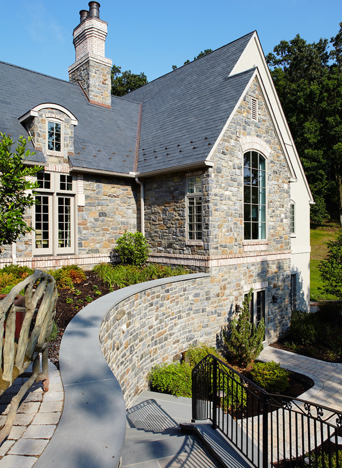 This is an example of a large and gey classic two floor house exterior in Philadelphia with stone cladding and a pitched roof.
