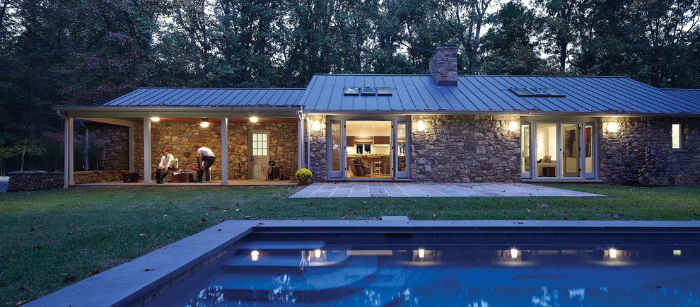Cette photo montre une très grande façade de maison beige nature en pierre de plain-pied avec un toit à deux pans.