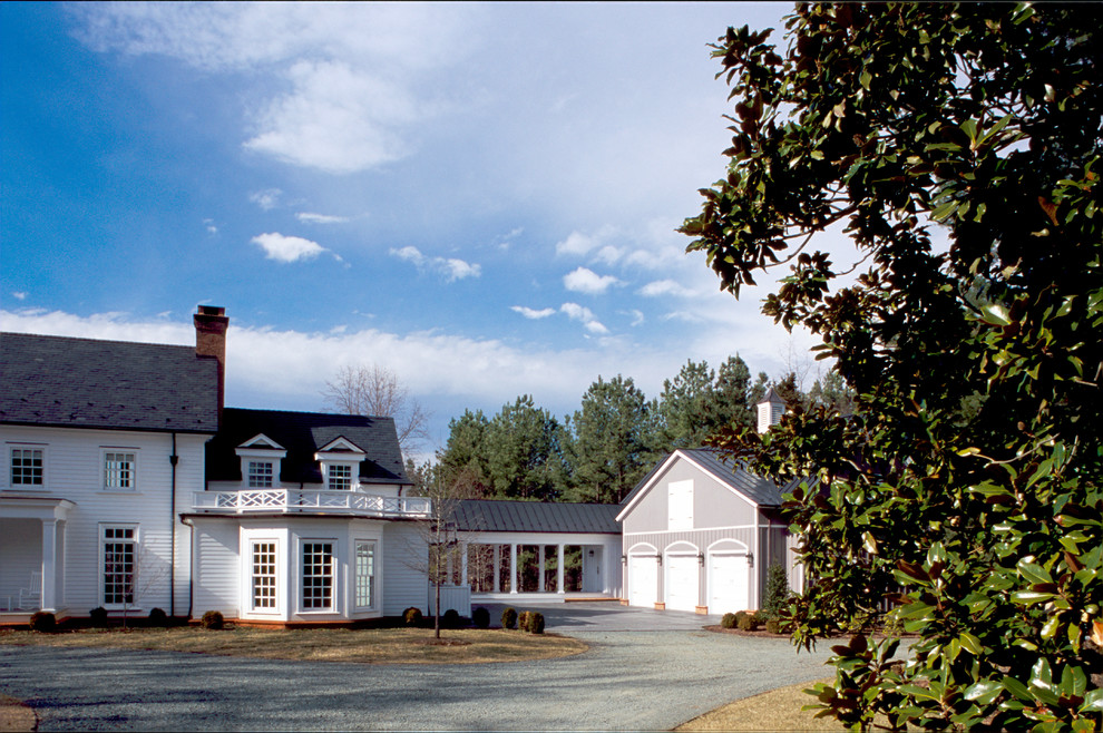 Réalisation d'une grande façade de maison blanche champêtre en bois à un étage avec un toit à deux pans et un toit en shingle.