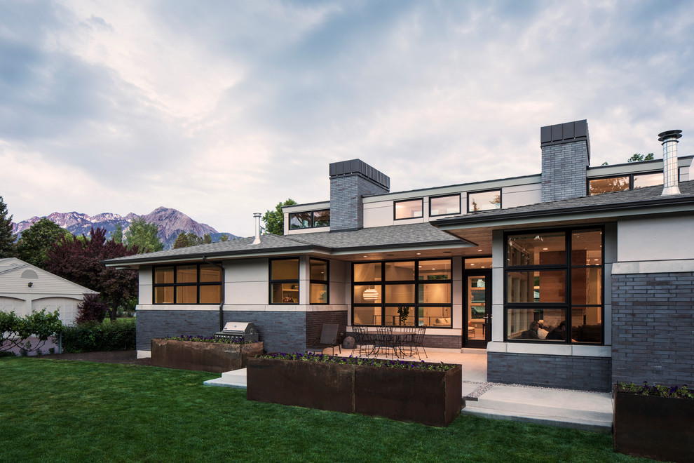 Idée de décoration pour une façade de maison grise design en brique de plain-pied et de taille moyenne avec un toit à quatre pans.
