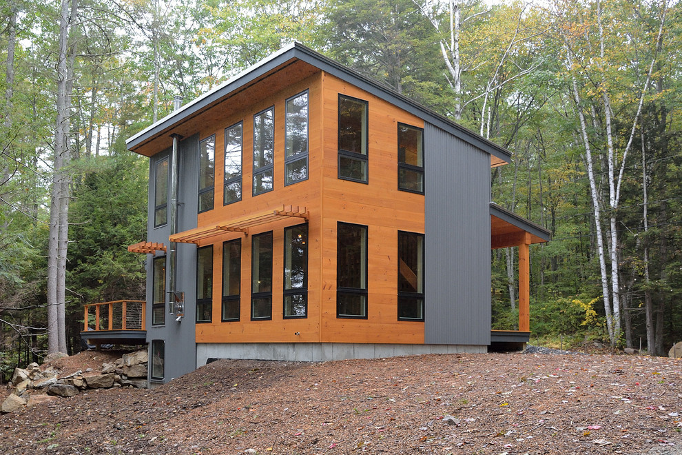 Foto de fachada marrón contemporánea de tamaño medio de tres plantas con revestimiento de madera y tejado de un solo tendido