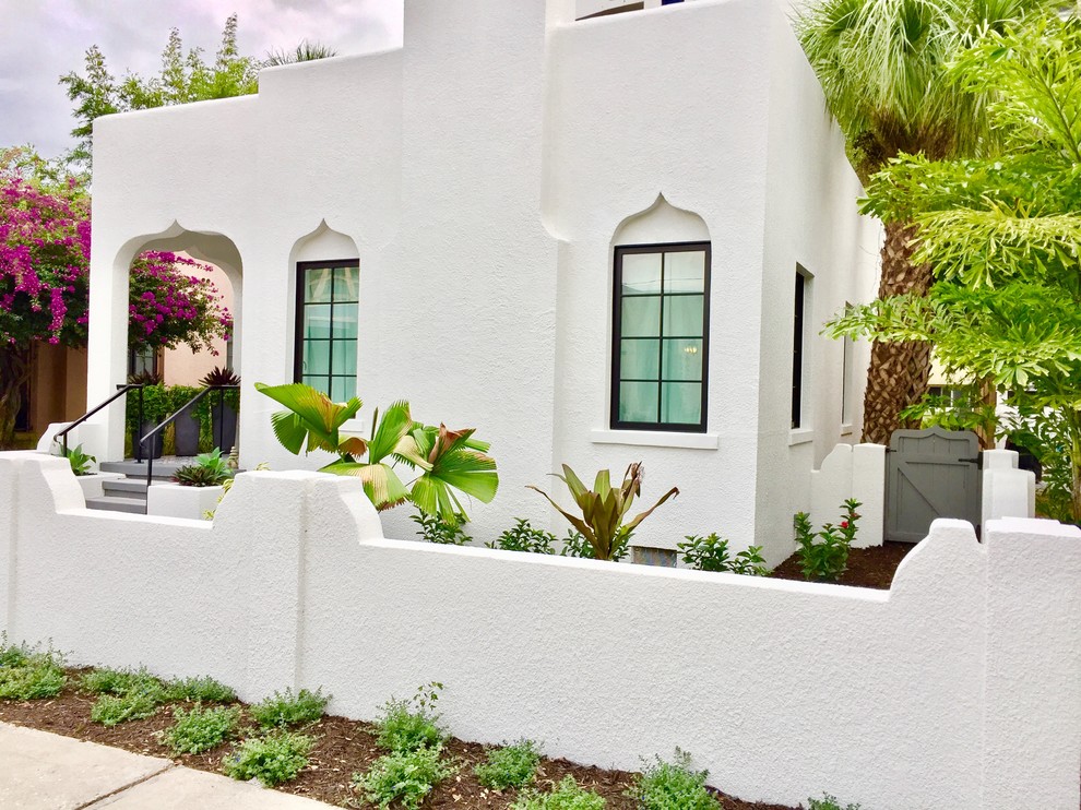 На фото: одноэтажный, белый частный загородный дом среднего размера в средиземноморском стиле с облицовкой из цементной штукатурки и плоской крышей с