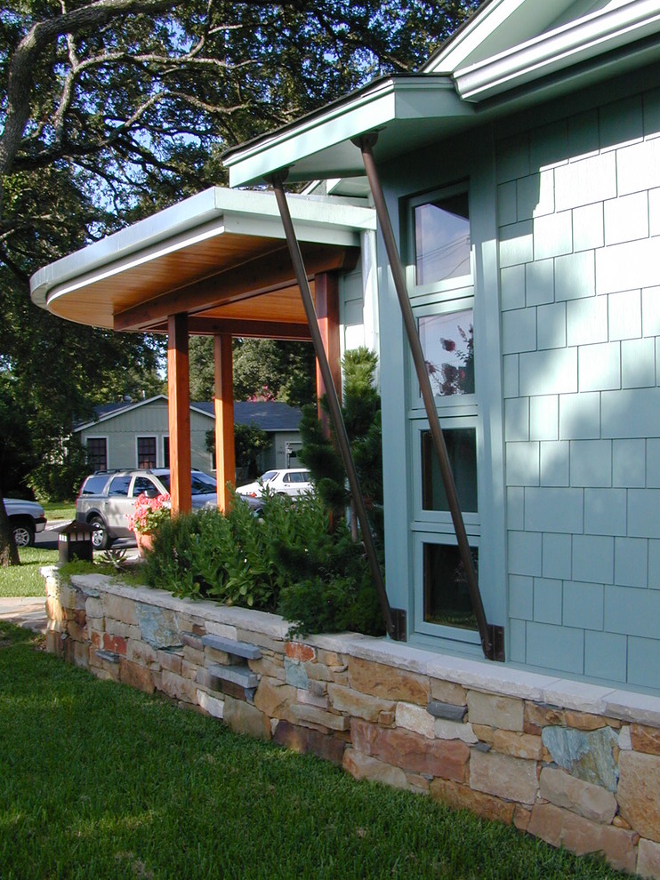 Idée de décoration pour une façade de maison bleue vintage de taille moyenne et à un étage avec un revêtement en vinyle et un toit à deux pans.