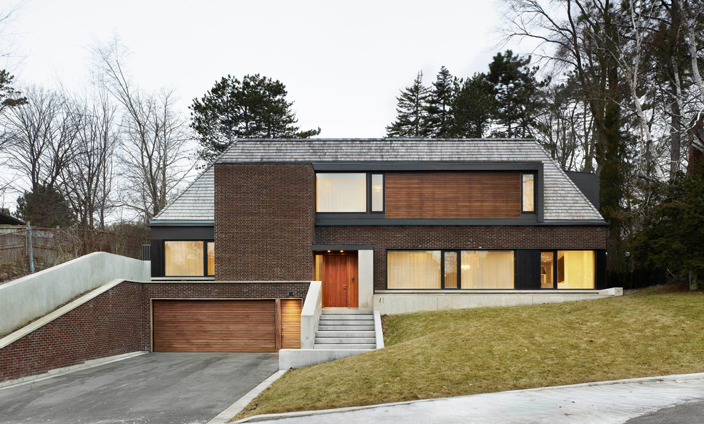 Idee per la facciata di una casa contemporanea a due piani con rivestimenti misti e tetto a padiglione