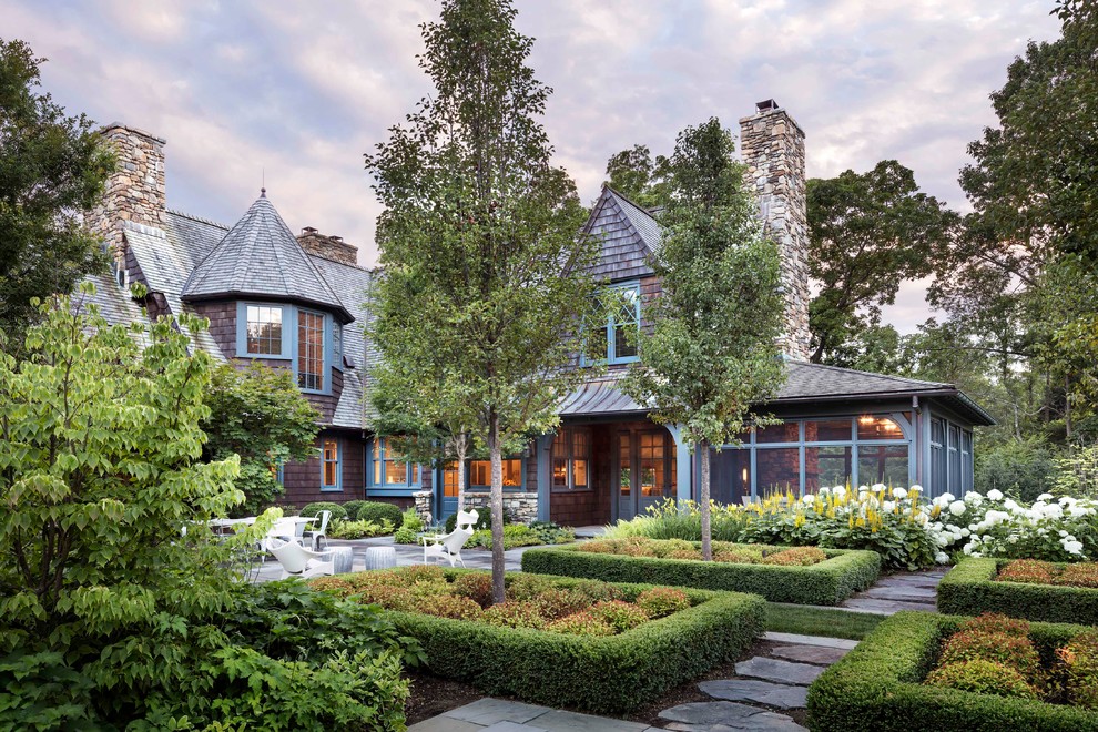 Cette image montre une grande façade de maison marron traditionnelle en bois à un étage avec un toit de Gambrel.