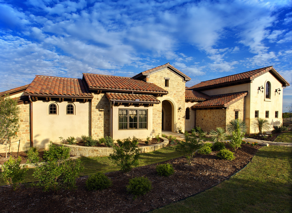 Diseño de fachada de casa marrón mediterránea grande de dos plantas con tejado de teja de barro, revestimientos combinados y tejado a dos aguas