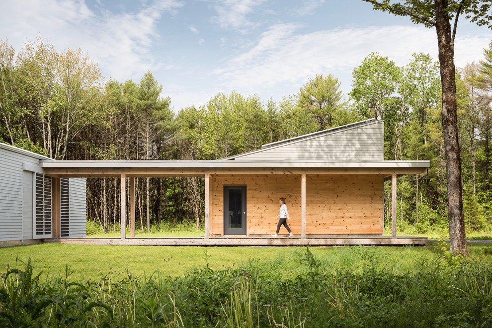 This is an example of a medium sized and gey contemporary bungalow house exterior in Portland Maine with wood cladding.