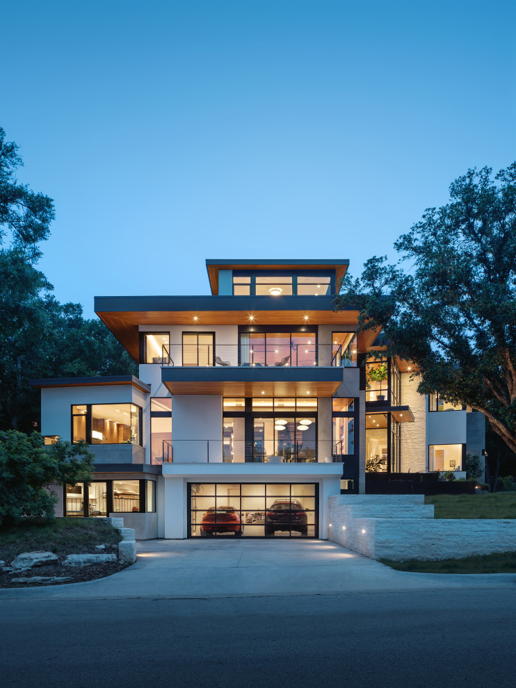 Vierstöckiges Modernes Einfamilienhaus mit weißer Fassadenfarbe und Flachdach in Austin