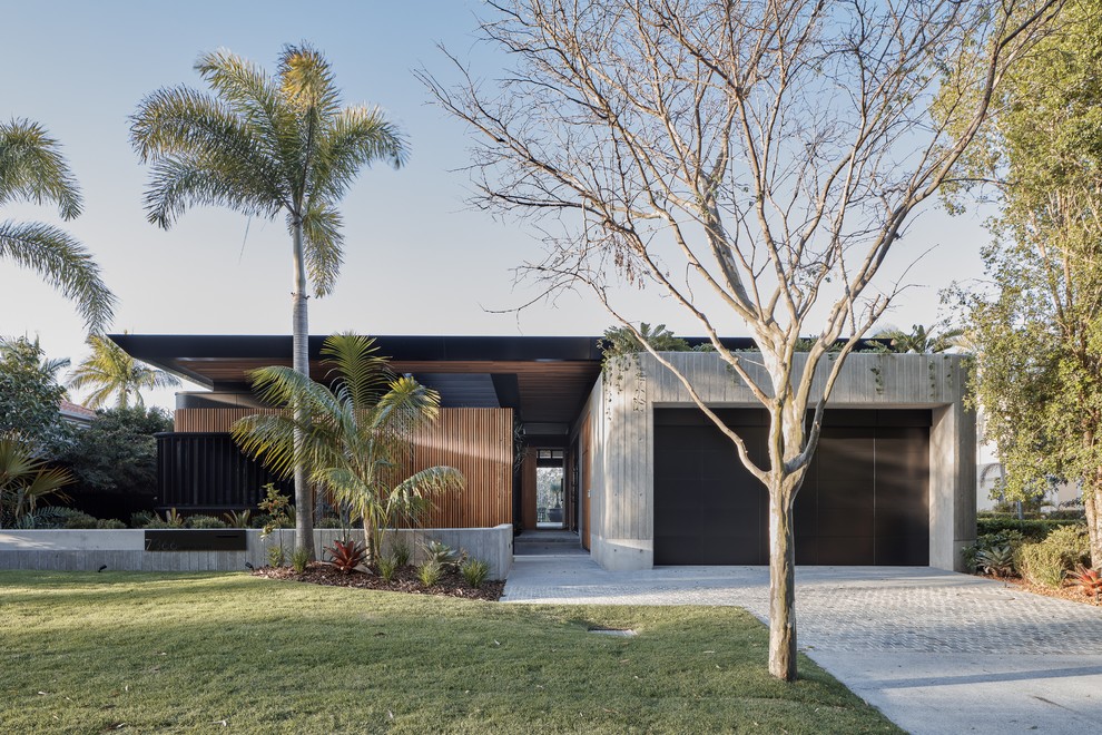 Foto de fachada de casa marrón contemporánea de una planta con revestimientos combinados y tejado plano