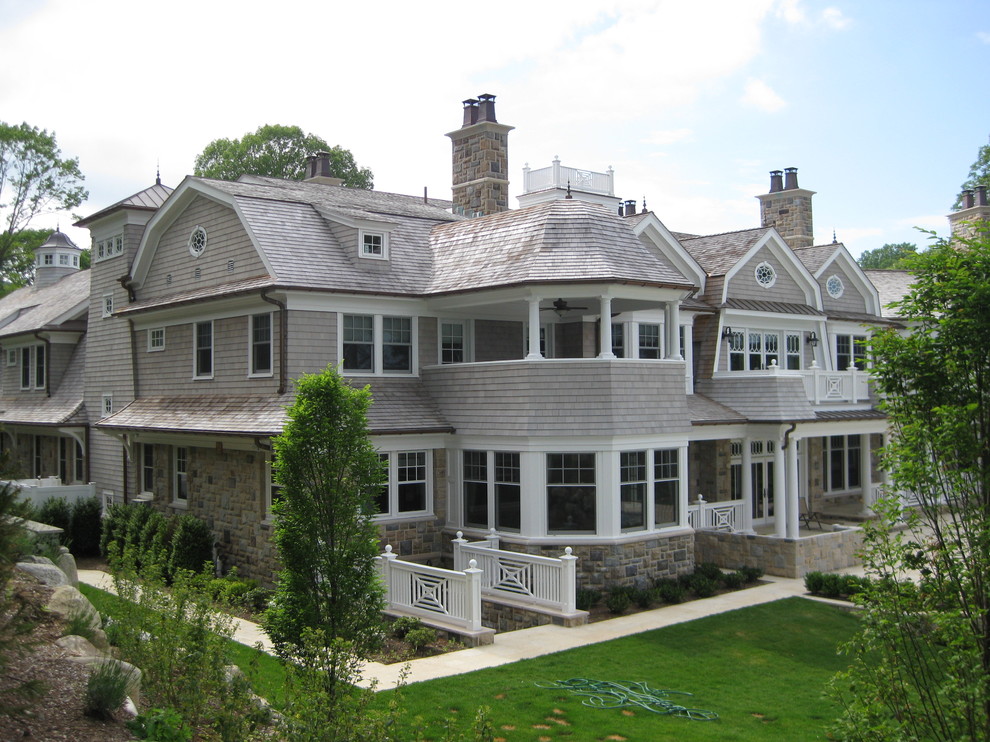 Foto della facciata di una casa ampia beige classica con rivestimento in pietra e tetto a mansarda