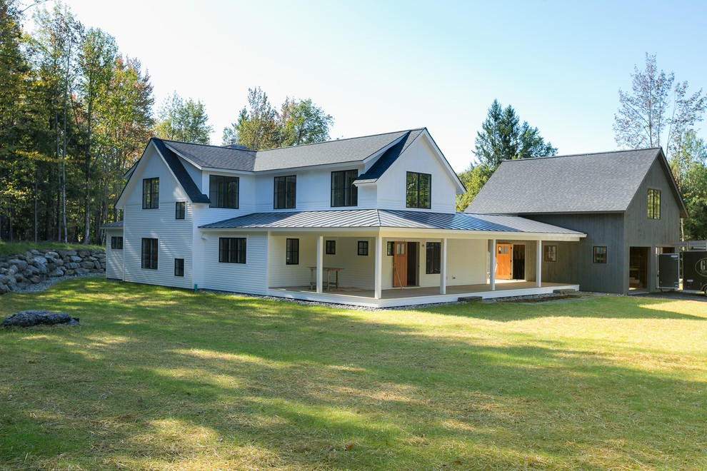 Cette image montre une façade de maison blanche rustique en bois à un étage avec un toit mixte.
