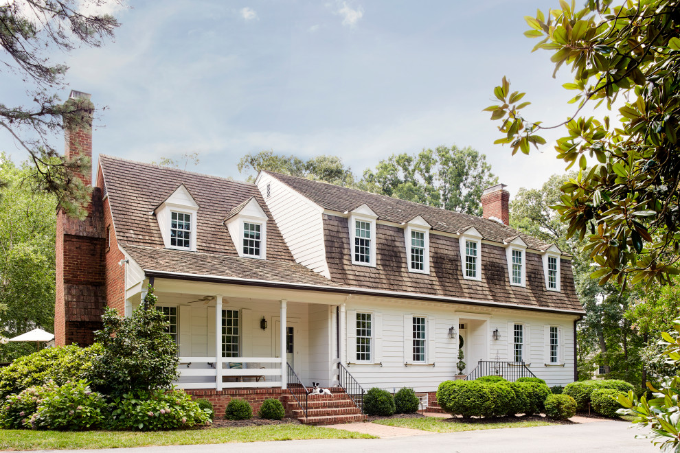 Cette photo montre une façade de maison blanche chic en bardage à clin à un étage avec un toit à deux pans, un toit en shingle et un toit marron.