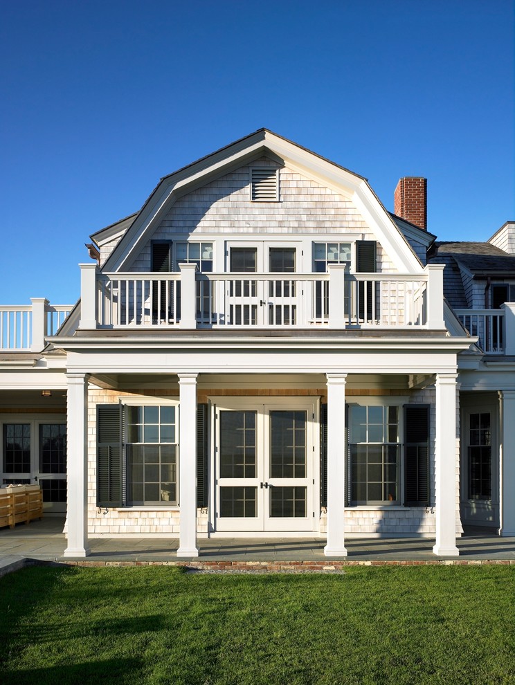 Immagine della facciata di una casa grande vittoriana a due piani con rivestimento in legno e tetto a mansarda