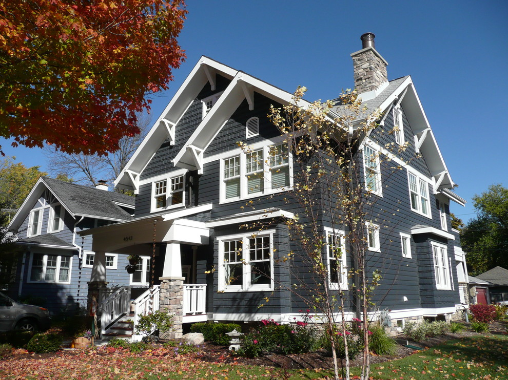Пример оригинального дизайна: трехэтажный, синий дом среднего размера в стиле кантри с комбинированной облицовкой и двускатной крышей