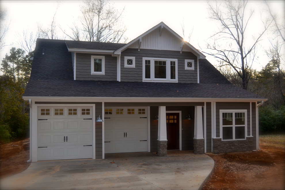 Cette photo montre une façade de maison grise craftsman de taille moyenne et à un étage avec un revêtement mixte et un toit à croupette.