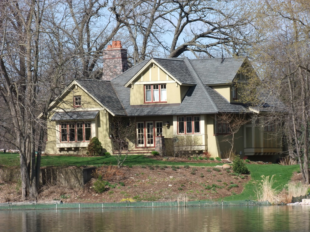 Aménagement d'une grande façade de maison verte craftsman en stuc à un étage avec un toit à deux pans et un toit en tuile.