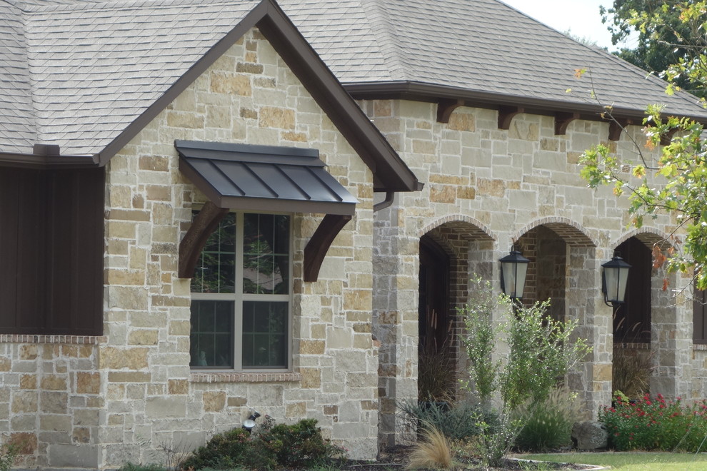 Large arts and crafts brown one-story mixed siding house exterior photo in Dallas with a hip roof and a shingle roof