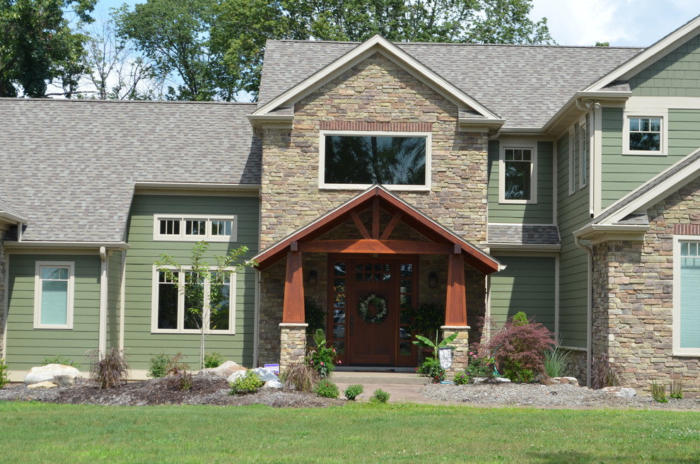 Cette image montre une grande façade de maison verte craftsman en panneau de béton fibré à un étage avec un toit de Gambrel.