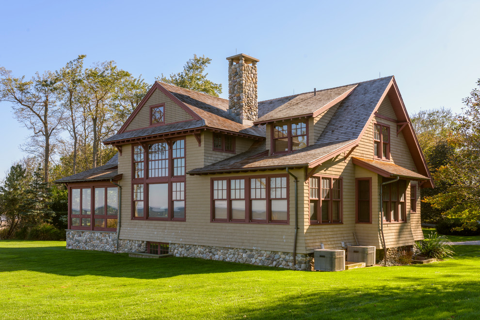 Imagen de fachada de casa marrón de estilo americano de dos plantas con tejado a dos aguas y tejado de teja de madera