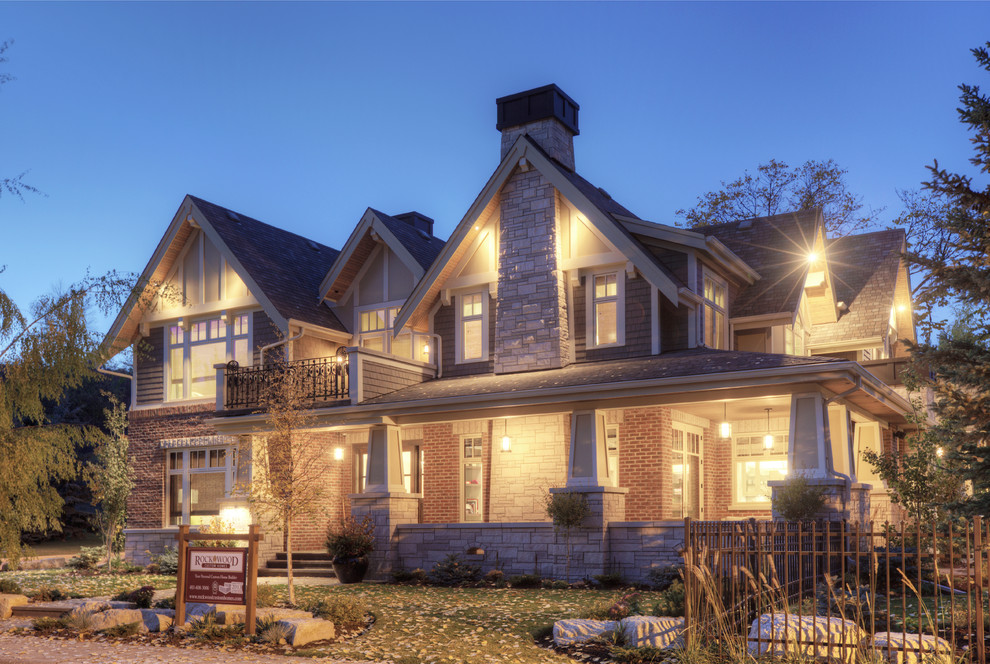 Inspiration for a large craftsman beige two-story brick exterior home remodel in Calgary with a shingle roof