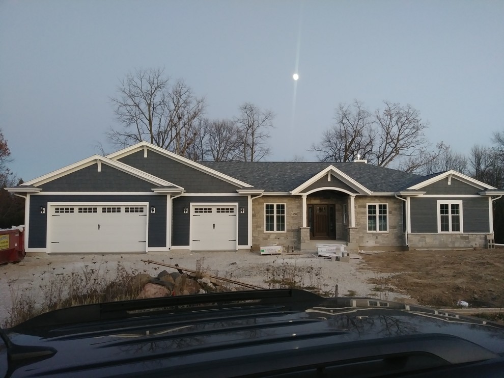 Medium sized and blue traditional bungalow detached house in Milwaukee with wood cladding, a hip roof and a shingle roof.