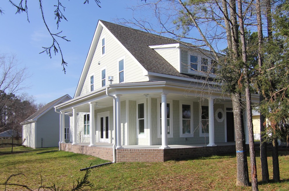 Foto della facciata di una casa piccola verde american style a due piani con rivestimento con lastre in cemento