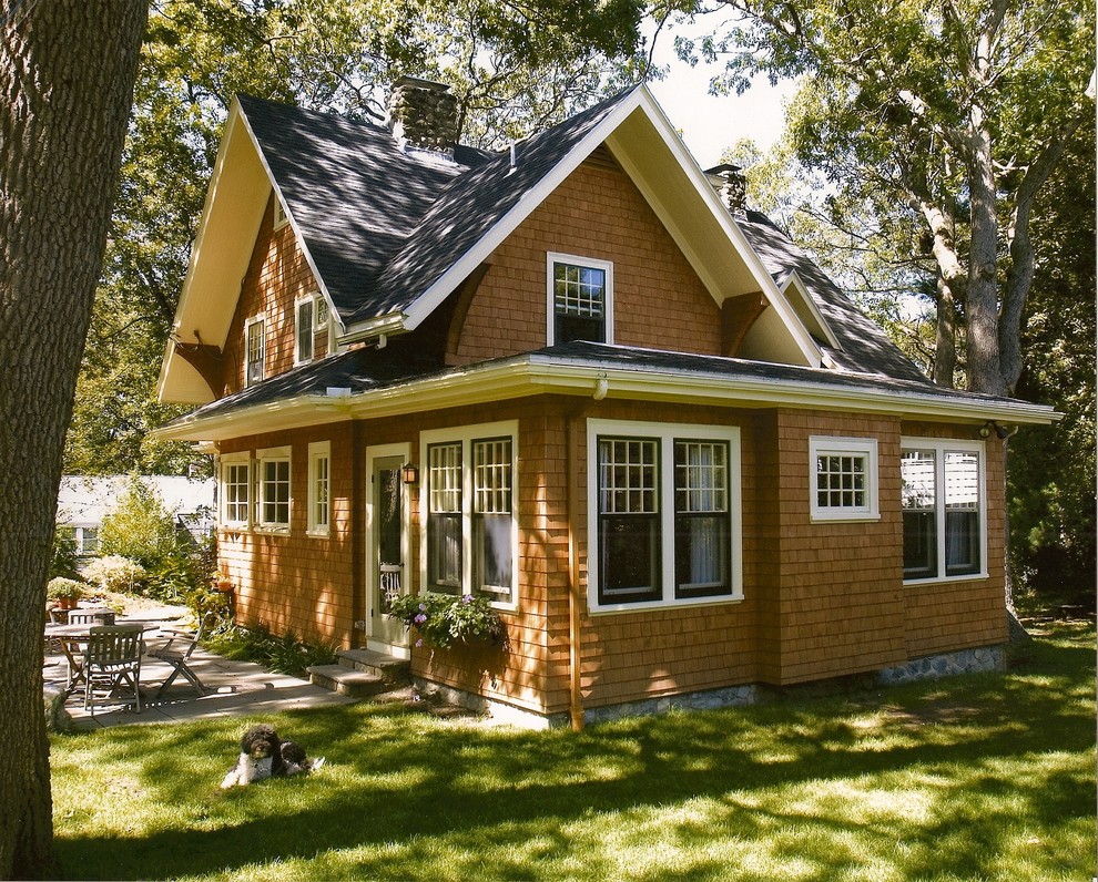 Idee per la villa piccola marrone american style a due piani con rivestimento in legno, tetto a capanna e copertura a scandole