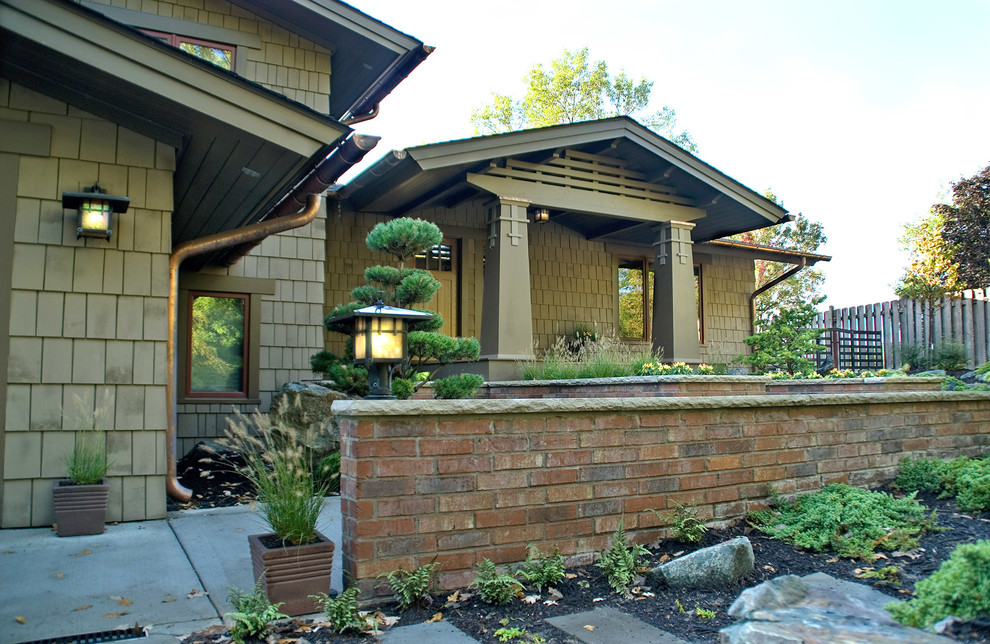 На фото: деревянный, зеленый дом среднего размера в стиле кантри с разными уровнями с