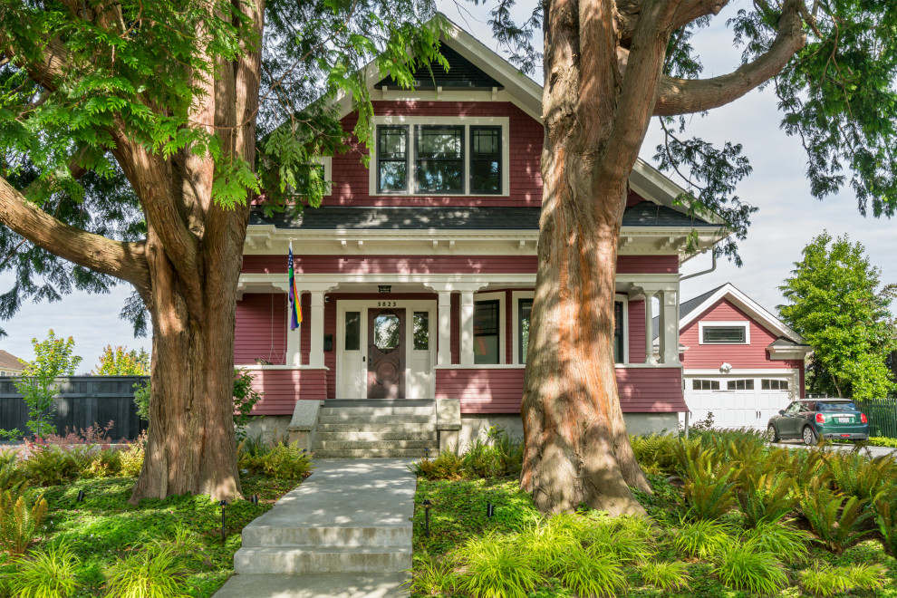 Foto della villa grande rossa american style a due piani con rivestimento in legno, tetto a capanna e copertura a scandole