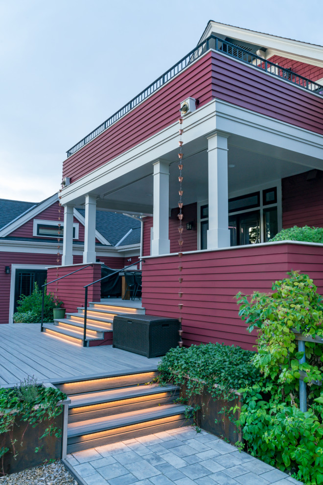 Immagine della villa grande rossa american style a tre piani con rivestimento in legno, tetto a capanna e copertura a scandole