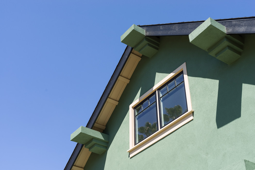 Inspiration pour une façade de maison verte craftsman en stuc de taille moyenne et à un étage avec un toit à deux pans et un toit en shingle.