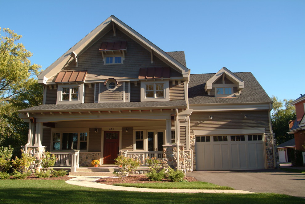 Modelo de fachada de casa gris de estilo americano grande de tres plantas con revestimientos combinados y tejado a dos aguas
