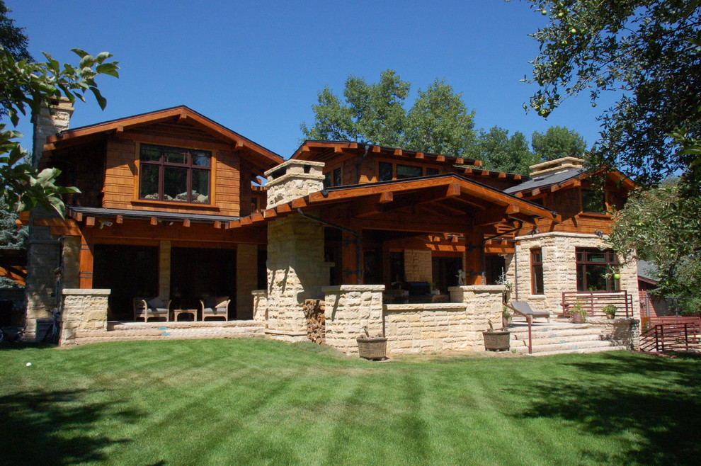 Ejemplo de fachada marrón de estilo americano grande de dos plantas con revestimientos combinados y tejado a dos aguas